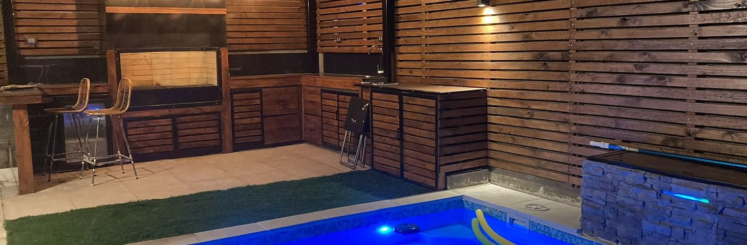 Piscina y quincho con iluminación nocturna